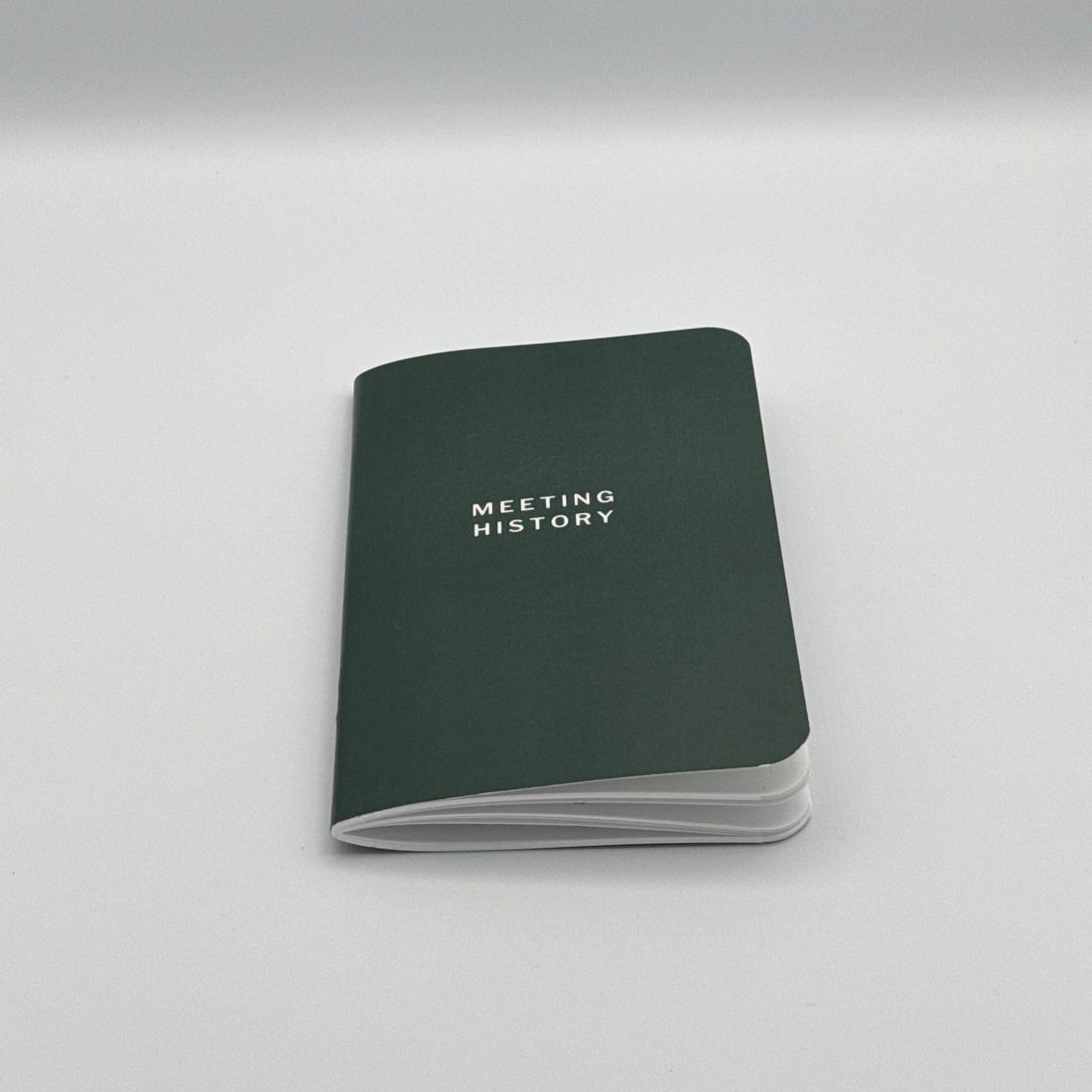 The Meeting History booklet, closed: dark green cover with MEETING HISTORY in white.